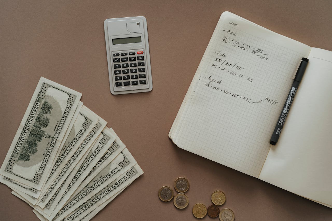 Flat lay with calculator, notebook, and US dollars ideal for financial concepts.